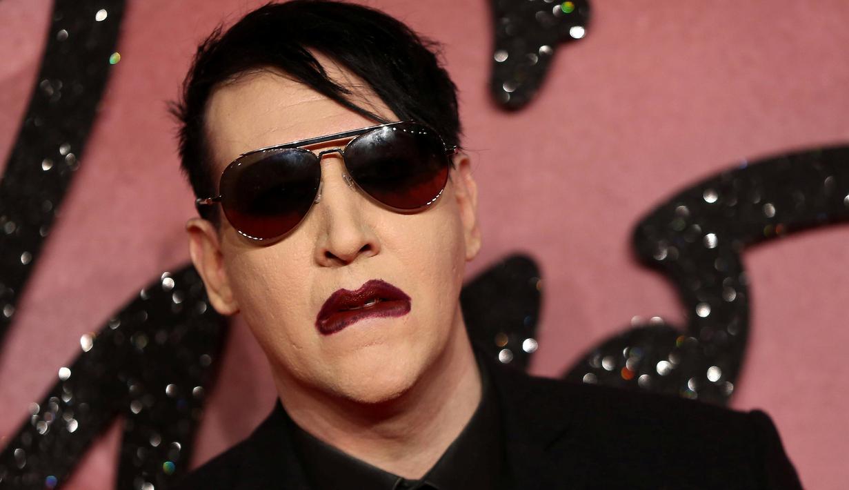 Pose Marilyn Manson saat menghidiri di Fashion Awards 2016 di London, Inggris (5/12). Mantan pacar Evan Rachel Wood tersebut tampil Fashionable dengan Jas dan kacamata hitam dengan gigi dan cincin ditangannya. (REUTERS/Neil Balai)