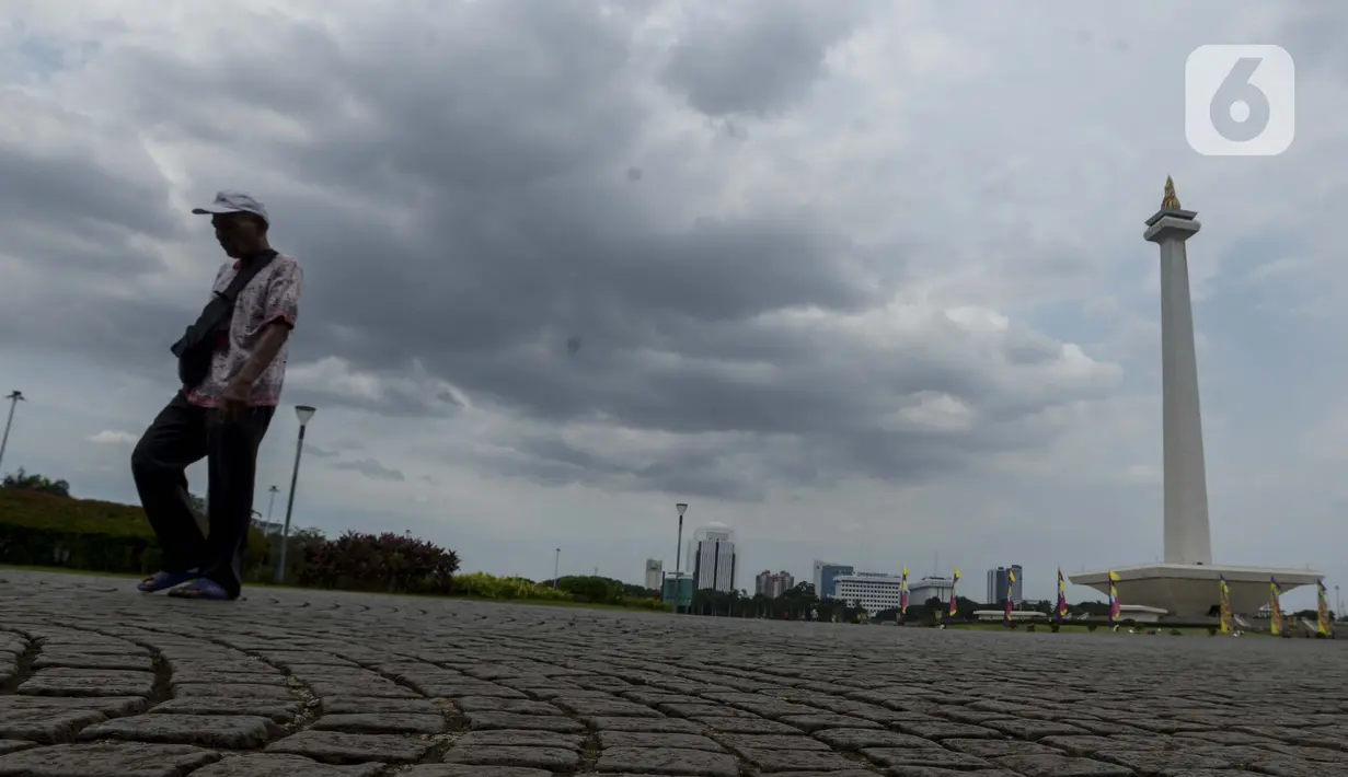 Pejalan kaki berjalan di kawasan Monumen Nasional (Monas) yang akan dijadikan arena lintasan balapan Formula E 2020, Jakarta, Selasa (11/2/2020). Formula E 2020 seri Jakarta akan memakai lintasan Monas untuk balapan mobil listrik Formula E pada 6 Juni 2020. (merdeka.com/Imam Buhori)