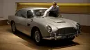 Seorang staf berpose dengan Aston Martin DB5 yang digunakan dalam film James Bond GoldenEye tahun 1995 di rumah lelang Bonham, London, Selasa (19/6). Mobil legendaris yang dikemudikan aktor Pierce Brosnan itu bakal dilelang pemiliknya. (AP/Matt Dunham)