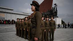 Tentara wanita Korea Utara berkumpul setelah memberi penghormatan kepada patung-patung pemimpin Korea Utara Kim Il Sung dan Kim Jong Il di Pyongyang (15/4). Hari ulang tahun Kim Il Sung merupakan salah satu hari libur di Korea Utara. (AFP Photo/Ed Jones)