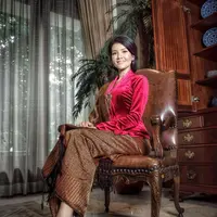 Penampilan elegan Farah Quinn berpose duduk mengenakan kebaya. Kebaya beludru berwarna merah ini, ia padukan dengan kain batik cokelat sebagai rok dan selendang yang senada yang disampirkannya di salah satu bahunya. [Foto: Instagram/farahquinnofficial]
