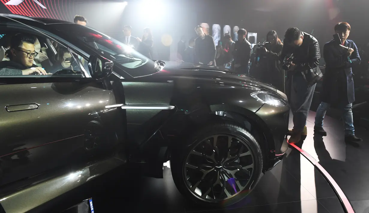 Awak media dan pengunjung melihat DBX, SUV pertama Aston Martin di Beijing, China, Rabu (20/11/2019). Mobil ini ditargetkan dapat menarik minat dari kalangan perempuan dengan sejumlah program penjualan dan fitur yang ditawarkan khusus untuk kaum hawa. (GREG BAKER / AFP)