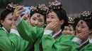 Pelajar berswafoto sambil mengenakan kostum tradisional Korea Selatan (Korsel) setelah upacara Coming of Age Day di Namsan Hanok Village, Seoul, Senin (15/5). Coming of age day atau Hari Kedewasaan dirayakan pada minggu ketiga bulan Mei. (Ed JONES/AFP)