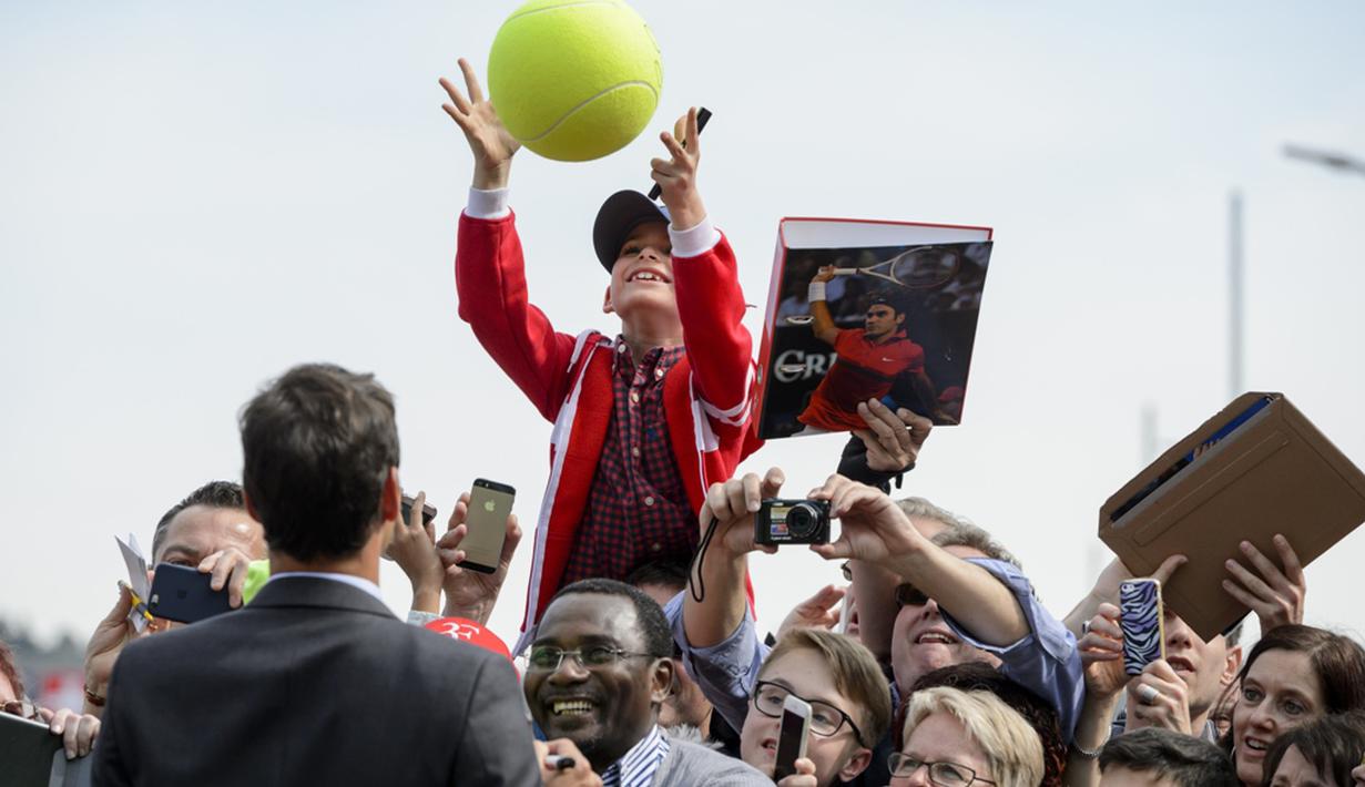 Seorang penggemar cilik menangkap bolanya kembali setelah ditanda tangani petenis Swiss, Roger Federer di Biel, Swiss, (21/4/2016). (AFP/Fabrice Coffrini)