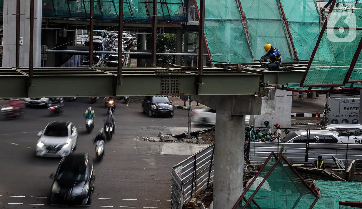 Kendaraan melintas dekat proyek pembangunan Jembatan layang (skybridge) CSW di Jakarta, Selasa (9/3/2021). Proyek pembangunan jembatan layang atau skybridge untuk integrasi Halte Transjakarta CSW di Stasiun MRT Asean ditargetkan selesai pada Mei 2021. (Liputan6.com/Johan Tallo)