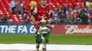 Aaron Ramsey berlari sambil membawa trofi Piala FA saat merayakan kemenangan Arsenal usai menumbangkan Hull City 3-2 di final di Stadion Wembley, London, (18/5/2014). (REUTERS/Eddie Keogh)