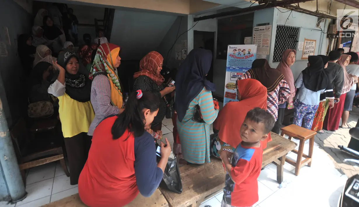 Warga antre membeli sembako murah dengan KJP di Pasar Blok G Tanah Abang, Jakarta, Selasa (11/12). Warga sangat antusias memanfaatkan KJP untuk membeli sembako murah karena harga yang lebih murah dari pasar. (Merdeka.com/Iqbal S. Nugroho)