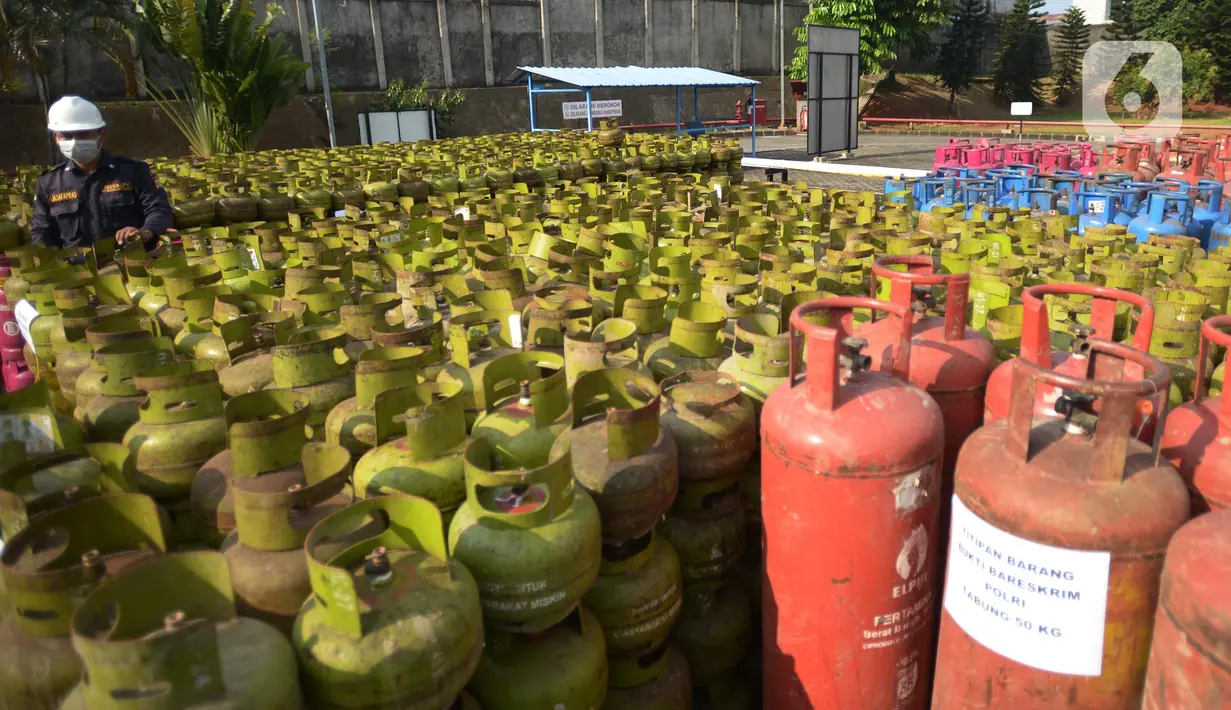Petugas mengecek tabung LPG bersubsidi  yang diamankan di Jakarta, Jumat (15/7/2022). Sebanyak, 3.344 tabung gas non subsidi yang dijual di pasaran  sebagai barang bukti yang telah diamankan bersama 14 tersangka. (merdeka.com/Imam Buhori)