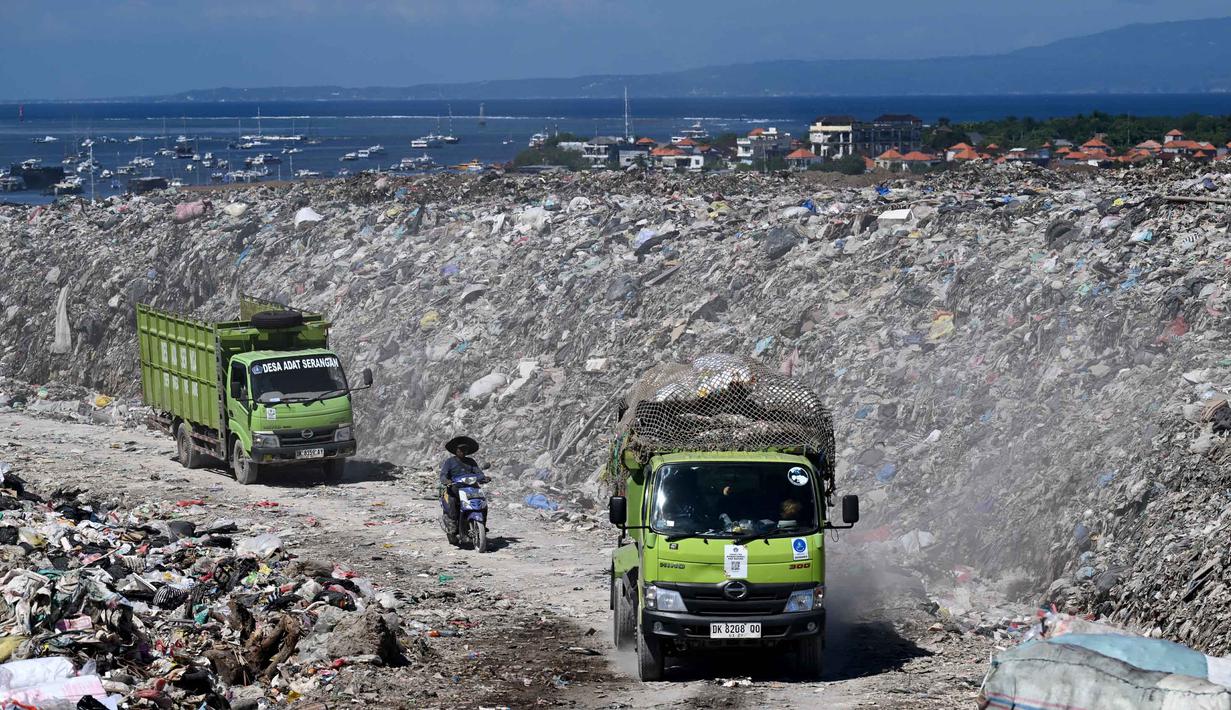 Namun, jadwalnya dibatasi hanya dua kali seminggu dari pukul 08.00 hingga 20.00 WITA. Tampak dalam foto, kendaraan melintas di dekat tumpukan sampah di Tempat Pembuangan Akhir (TPA) Suwung berlatar belakang salah satu lokasi wisata di Denpasar, Bali, pada Jumat 17 April 2026. (SONNY TUMBELAKA/AFP)