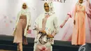Sebuah busana muslim dengan motif bunga dipergakan oleh seorang model pada Indonesia Moslem Fashion di Gedung Kementerian Perdagangan RI, Jakarta, Rabu (29/10/2014) (Liputan6.com/Faizal Fanani)
