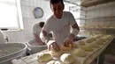 Pekerja membuat adonan somun di sebuah toko roti di kota tua Sarajevo, Bosnia and Herzegovina, Kamis (30/4/2020). Roti somun terbuat dari tepung, air hangat, dan garam sebagai penyedap. (ELVIS BARUKCIC/AFP)