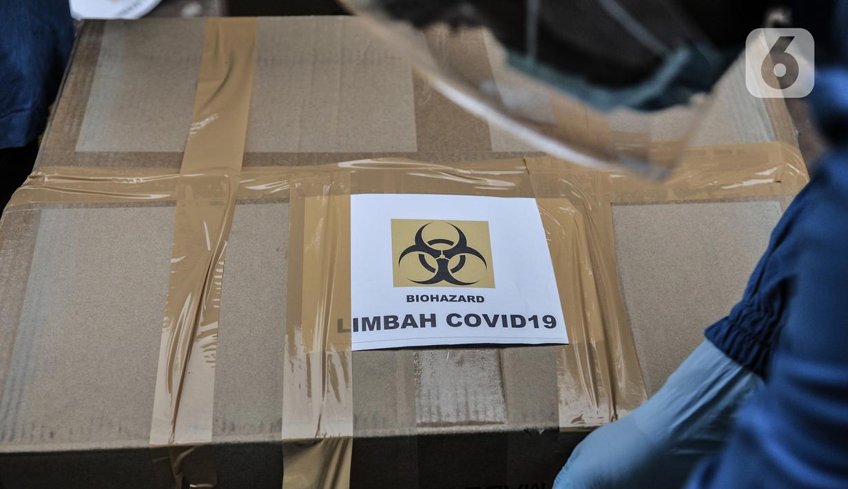 Petugas memasangkan label Covid-19 pada salah satu kardus di Tempat Penyimpanan Sementara Limbah B3 di Laboratorium Kesehatan Daerah (Labkesda) DKI Jakarta, Selasa (4/8/2020). Selama pandemi, jumlah limbah Covid-19 di Labkesda DKI mencapai 70 kilogram setiap harinya. (merdeka.com/Iqbal Nugroho)