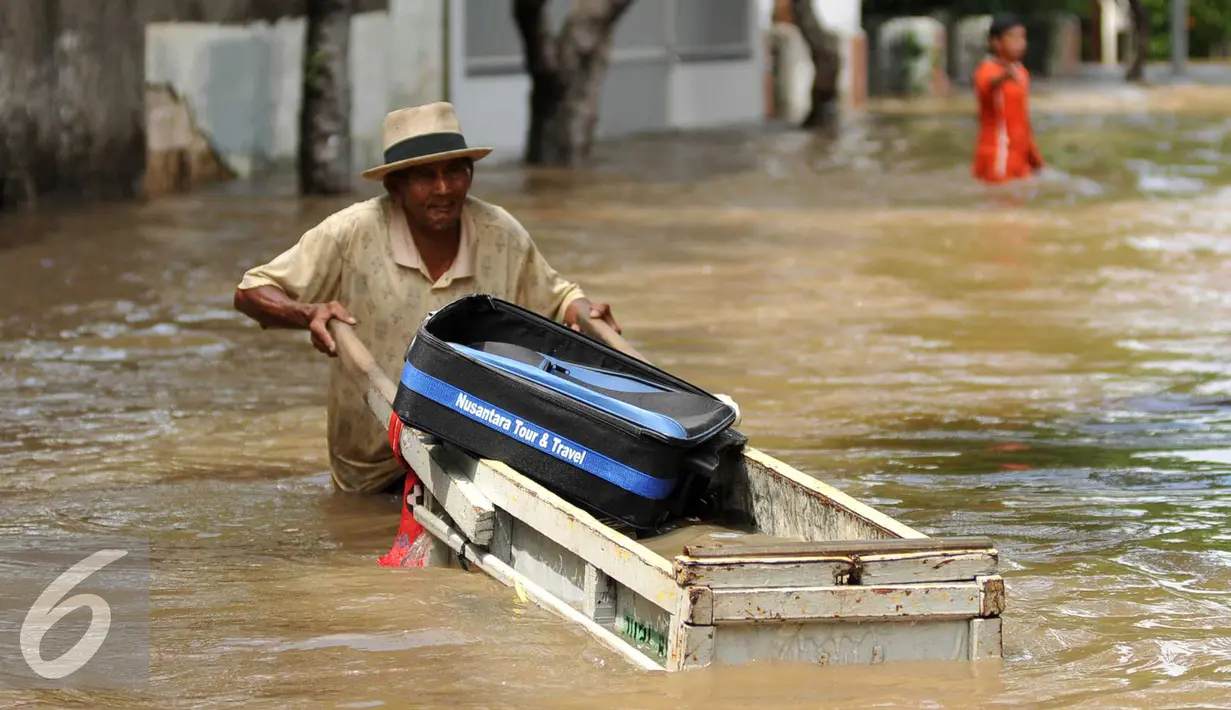 Warga menerobos banjir di kawasan komplek Polri jalan Pondok Karya, Mampang, jakarta, kamis (21/4). Akibat pintu air di Depok dibuka kali mampang meluap dan menyebabkan banjir di kawasan tersebut. (Liputan6.com/Gempur M Surya)