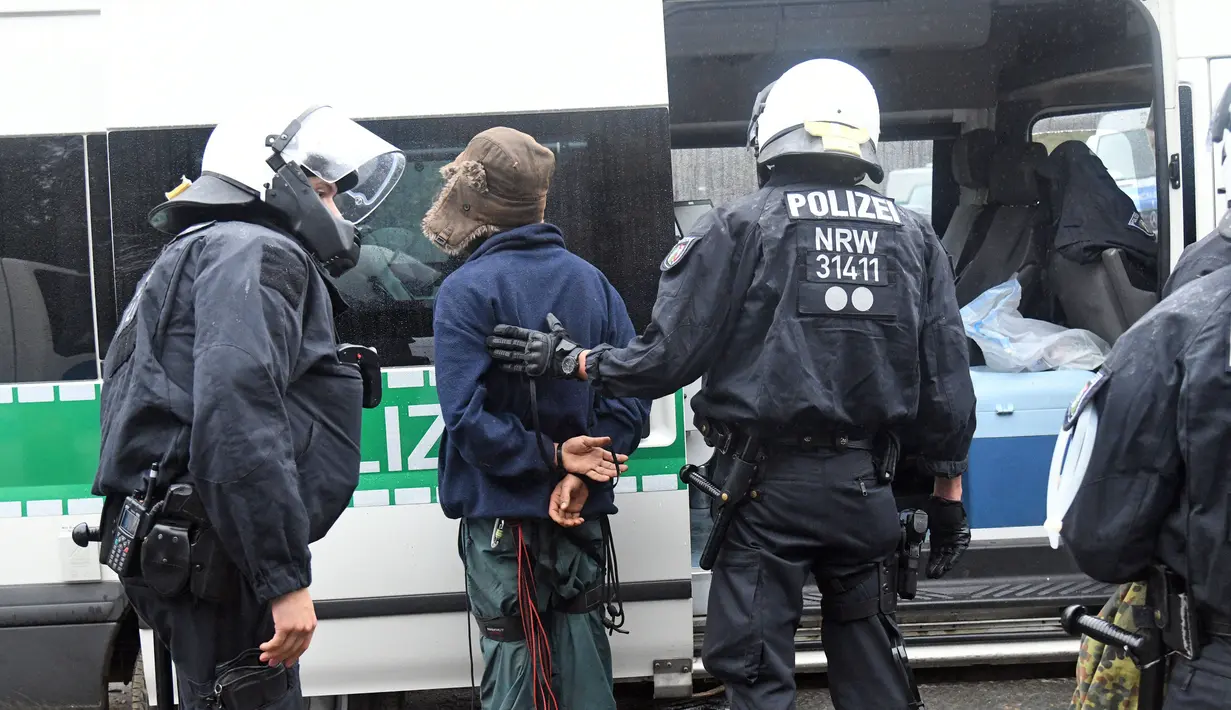 Polisi membawa aktivis lingkungan dari sebuah rumah pohon di hutan Hambacher Forst di Kerpen, Jerman Barat (13/9). Aktivis yang tinggal di rumah pohon tersebut menghadapi penggusuran paksa oleh polisi. (Henning Kaiser/dpa/AFP)