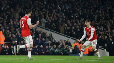 Pemain Arsenal Sokratis Papastathopoulos (kiri) merayakan dengan rekan setimnya Lucas Torreira usai mencetak gol ke gawang Manchester United pada pertandingan lanjutan Liga Inggris di Emirates Stadium, London, Rabu (1/1/2020). Arsenal menang 2-0. (AP Photo/Matt Dunham)