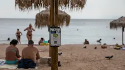 Pengisi daya bertenaga surya terpasang pada payung di pantai dekat Balai Kota Vari-Voula-Vouliagmeni, Yunani, Selasa (21/7/2020). Puluhan payung di pantai tersebut dilengkapi sistem panel surya dan port USB untuk menyediakan pengisian daya gratis dan ramah lingkungan. (Xinhua/Lefteris Partsalis)