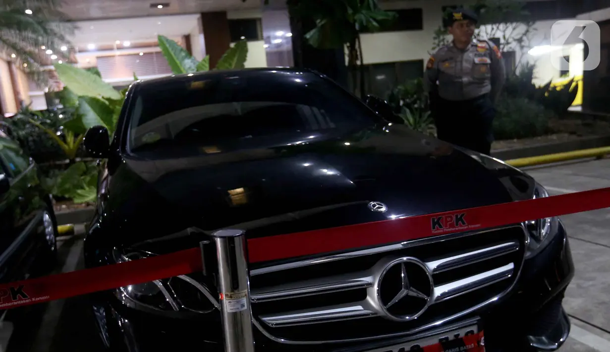 Petugas menjaga salah satu mobil yang disita dari hasil Operasi Tangkap Tangan (OTT) yang menjerat Kepala Kantor Imigrasi Jakarta Barat tiba di Gedung Merah Putih Komisi Pemberantasan Korupsi (KPK), Jakarta, Rabu (3/6/2026). (Liputan6.com/Helmi Fithriansyah)