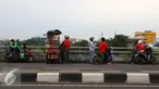 Pengendara sepeda motor menepikan kendaraannya di atas jalan layang Pasar Rebo, Jakarta, Sabtu (14/1). Setiap hari, jalan layang tersebut menjadi tempat untuk menghabiskan waktu bagi warga sekitar serta pemotor. (Liputan6.com/Immanuel Antonius)