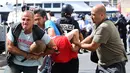 Seorang fans Inggris ditahan oleh polisi menyusul bentrokan antara fans Inggris dan polisi di kota Marseille, Prancis (11/6/2016). Bentrok terjadi menjelang pertandingan sepak bola Euro 2016 antara Inggris dan Rusia. (AFP Photo/Leon Neal)