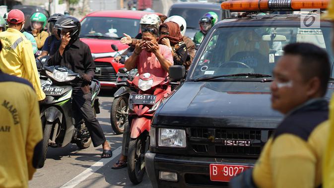 Petugas Sudin Bina Marga Jakarta Barat membagikan masker dan pasta gigi kepada pengendara motor di Jalan KS Tubun, Petamburan, Kamis (23/5/2019). Sisa gas air mata untuk membubarkan massa dalam kericuhan aksi 22 Mei masih terasa dan mengganggu aktvitas pengguna jalan (Liputan6.com/Immanuel Antonius)