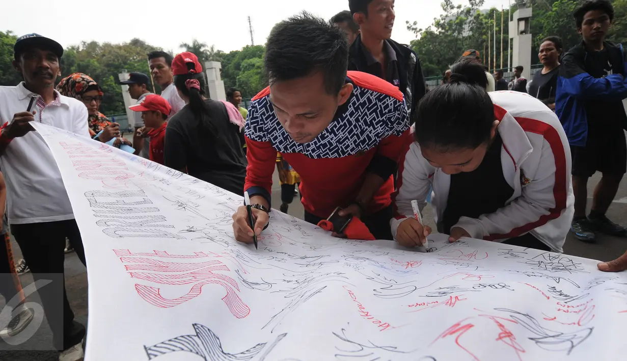 Warga menandatangi spanduk dukungan terhadap pengemudi angkutan berbasis online di kawasan Stadion GBK Jakarta, Minggu (28/8). Selain meminta dukungan tanda tangan warga, mereka melakukan survey kepuasan pelayanan. (Liputan6.com/Helmi Fithriansyah)