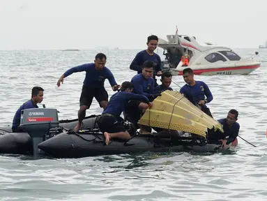 Tim SAR mengevakuasi bagian tubuh penumpang pesawat Sriwijaya Air SJ 182 di perairan Kepulauan Seribu, Jakartra, Minggu (10/1/2021). Sriwijaya Air SJ 182 hilang kontak empat menit usai lepas landas dari Bandara Soetta. (merdeka.com/Arie Basuki)