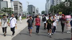 Sejumlah remaja beraktivitas di antara peserta Reuni 212 saat Car Free Day (CFD) di kawasan Jakarta, Minggu (2/12). Warga tetap memadati area Car Free Day  dari Bundaran HI-Sudirman meskipun ada aksi Reuni 212. (Liputan6.com/Angga Yuniar)