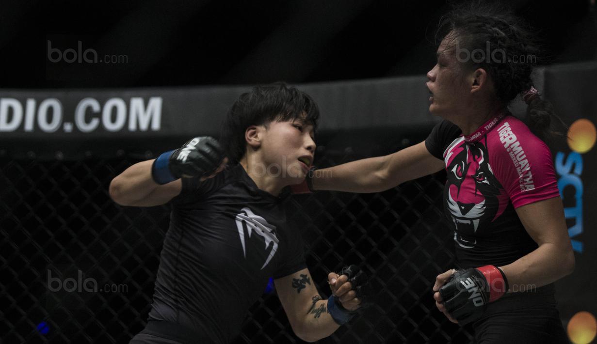 Petarung Cina, Xiong Jing Nan, menghindari pukulan petarung Singapura, Tiffany Teo, saat laga One Championship di JCC Senayan, Jakarta, Sabtu (20/1/2018). Jing Nan berhasil merebut juara dunia kelas jerami. (Bola.com/Vitalis Yogi Trisna)