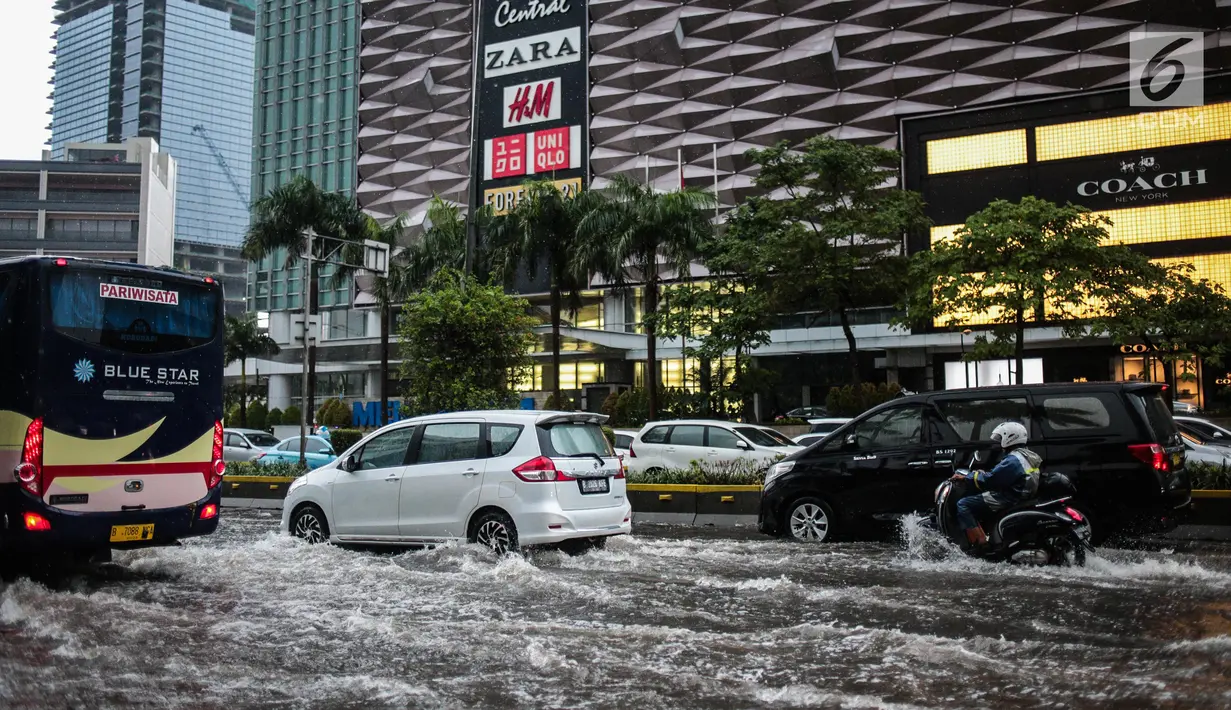Sejumlah kendaraan melintas menerjang genangan air di kawasan Bunderan HI, Jakarta, Kamis (22/11). Genangan air hujan setinggi 40 cm tersebut disebabkan hujan deras yang melanda Jakarta pada siang hari. (Liputan6.com/Faizal Fanani)