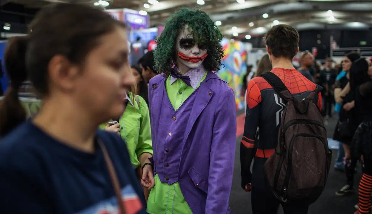 Seorang cosplayer berkostum ala karakter The Joker berjalan melalui kerumunan orang dalam acara Comic Con Africa di Johannesburg, Sabtu (21/9/2019). Comic Con Africa untuk tahun kedua di benua itu  akan berlangsung selama empat hari dari 21 hingga 24 September. (Michele Spatari/AFP)