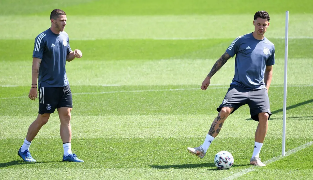 Pemain Jerman Ronin Koch (kanan) dan Robin Gosens saat sesi latihan MD-1 di Herzogenaurach, Jerman, Senin (28/6/2021). Jerman akan melawan Inggris pada babak 16 besar Euro 2020. (Christof STACHE/AFP)