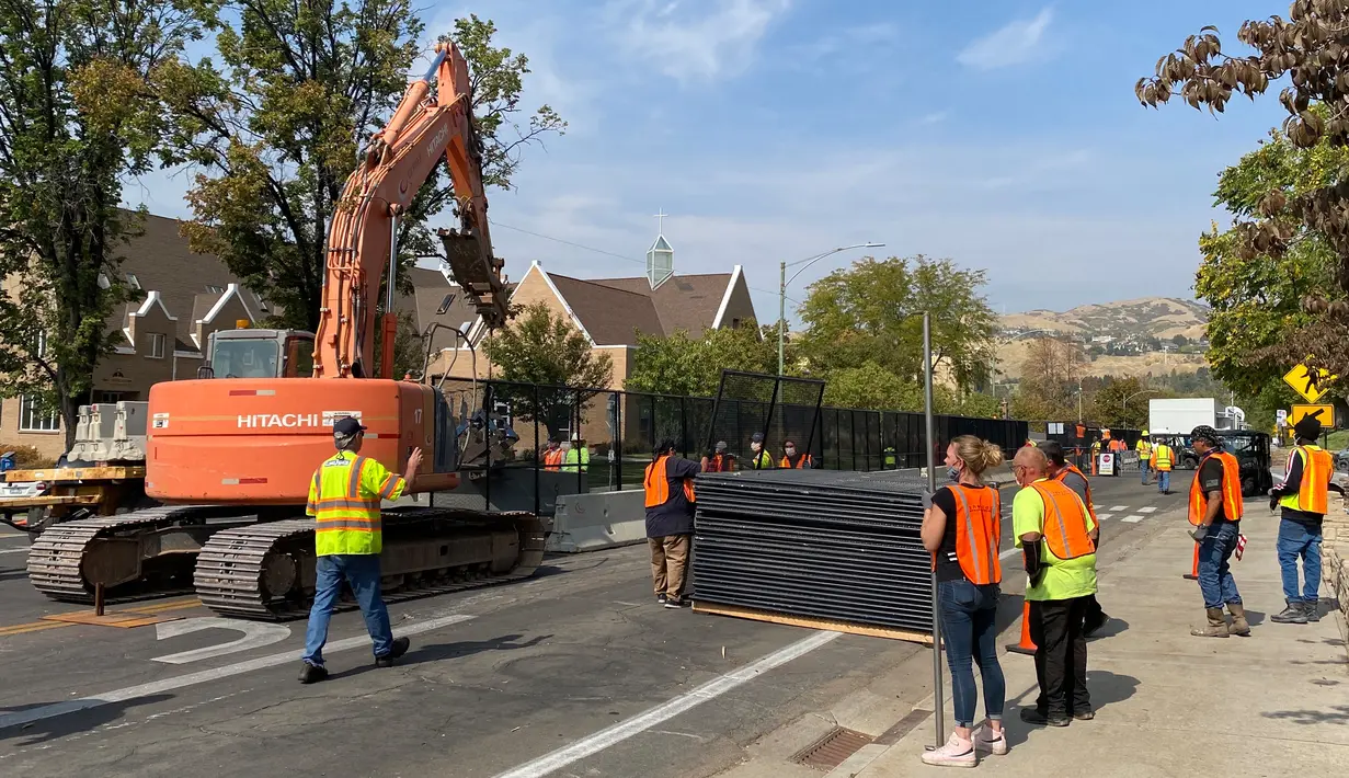 Pekerja mendirikan barikade beton dan pagar sementara di luar kompleks Universitas Utah di Salt Lake City, Senin (5/10/2020). Universitas Utah akan menjadi tuan rumah debat calon wakil presiden petahana Mike Pence dan Senator California Kamala Harris akan digelar pada Rabu 7 Oktober. (Daniel SLIM /
