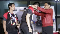 Ketum PP PBSI, Wiranto, mengalungkan bunga kepada pasangan ganda putra Indonesia, Mohammad Ahsan/Hendra Setiawan, di Bandara Soekarno-Hatta, Tangerang, Selasa (27/8). Ahsan/Hendra meraih gelar pada Kejuaraan Dunia Bulutangkis 2019. (Bola.com/Yoppy Renato)