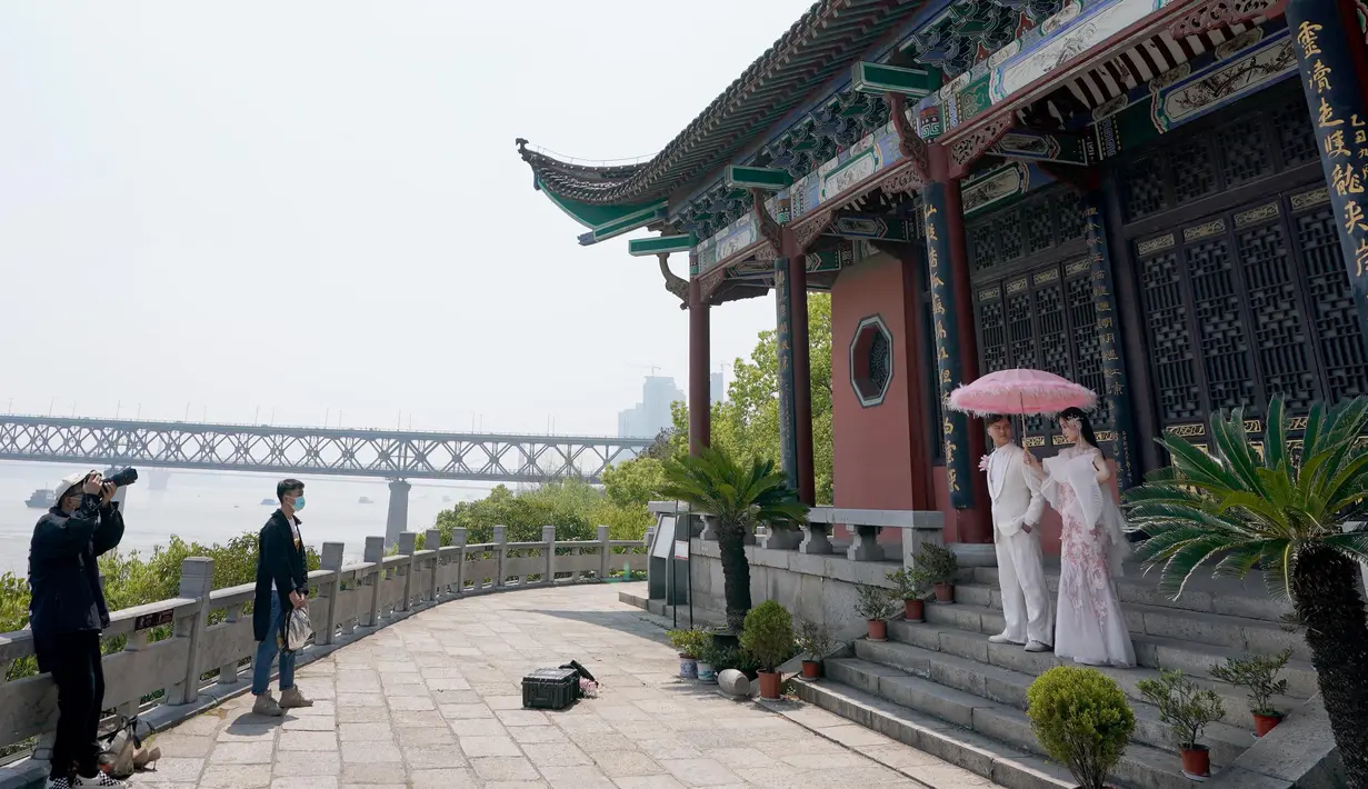 Sepasang calon pengantin berpose dalam sesi foto pranikah di Paviliun Qingchuan, Wuhan, Provinsi Hubei, China tengah, pada 12 April 2020. Warga Wuhan kembali melakukan persiapan pernikahan setelah meredanya pandemi corona Covid-19. (Xinhua/Wang Yuguo)