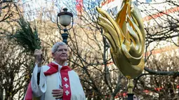 Uskup Agung Paris Laurent Ulrich memberkati ayam jantan itu dengan sayap emas seperti api sebelum diangkat ke tempatnya di puncak menara katedral setinggi 96 meter (315 kaki). (Thomas SAMSON / AFP)