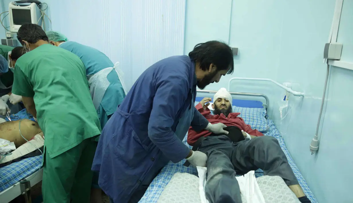 Dokter mengecek kondisi pria korban serangan bom bunuh diri di rumah sakit Wazir Akbar Khan di Kabul, Afghanistan (31/10). Dilaporkan sedikitnya 4 Orang tewas dan puluhan lainnya luka-luka akibat serangan tersebut. (AP Photo/Massoud Hossaini)