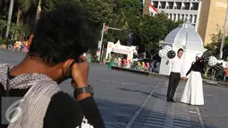 Sepasang calon pengantin melakukan foto pranikah di kawasan Kota Tua, Jakarta, Kamis (29/9). Gubernur DKI Jakarta Basuki Tjahaja Purnama memastikan aktivitas foto pranikah di Kota Tua tidak dipungut biaya. (Liputan6.com/Immanuel Antonius)