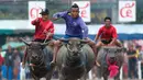 Sejumlah joki saat bersaing pada festival lomba balap kerbau di Chonburi, Bangkok, Thailand  (16/7). Festival tahunan di Thailand ini merupakan tradisi untuk menyambut datangnya musim panen padi. (AP Photo/Sakchai Lalit)