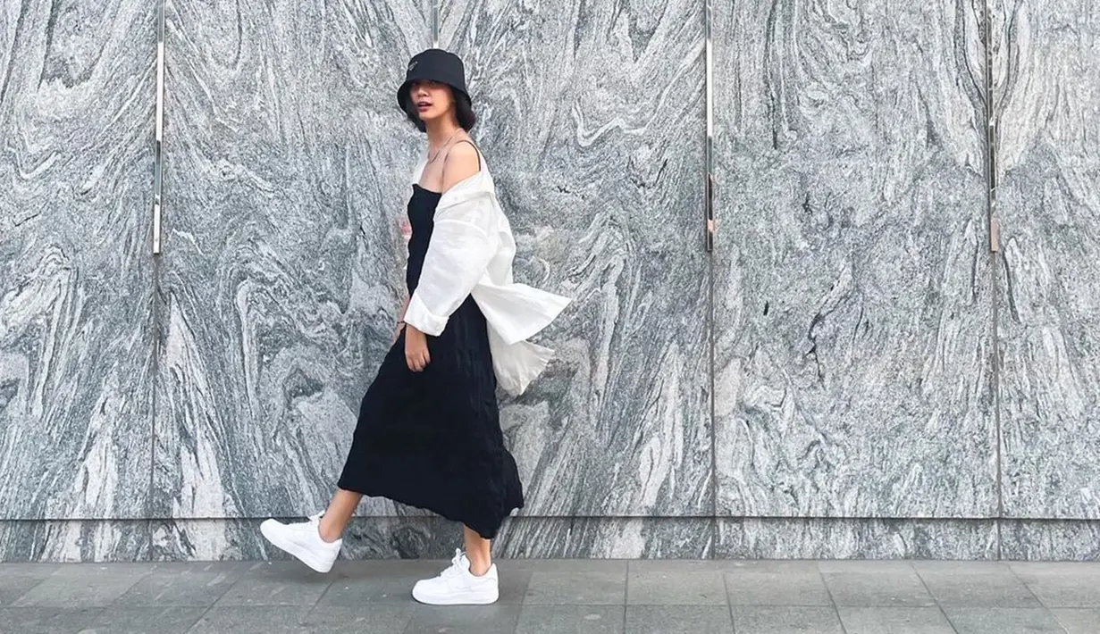 Simple dress berwarna hitam yang dipadukan dengan kemeja oversize putih ini pun enggak bakal bikin mati gaya. Calon istri Vidi Aldiano ini juga terlihat memadukan gaya penampilannya dengan topi serta sneakers berwarna senada. (Liputan6.com/IG/@sheiladaisha)