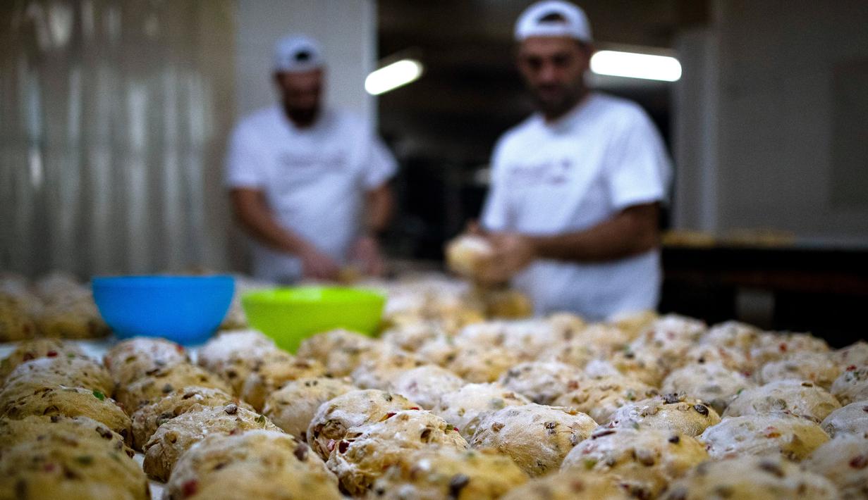 Tukang roti menyiapkan adonan untuk membuat Bolo Rei atau Kue Raja di toko roti Padaria da Ne, Amadora, Portugal, 16 Desember 2022. National Association of Bread and Pastry Producers memberikan hadiah tahunan untuk Bolo Rei terbaik di Portugal. (CARLOS COSTA/AFP)