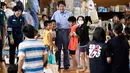 c mengunjungi pusat evakuasi korban banjir di Mabi, Prefektur Okayama, Rabu (11/7). Sekitar 74 ribu relawan dan penyelamat pun diterjunkan untuk membantu proses pencarian dan penyelamatan korban. (AFP/Martin BUREAU)