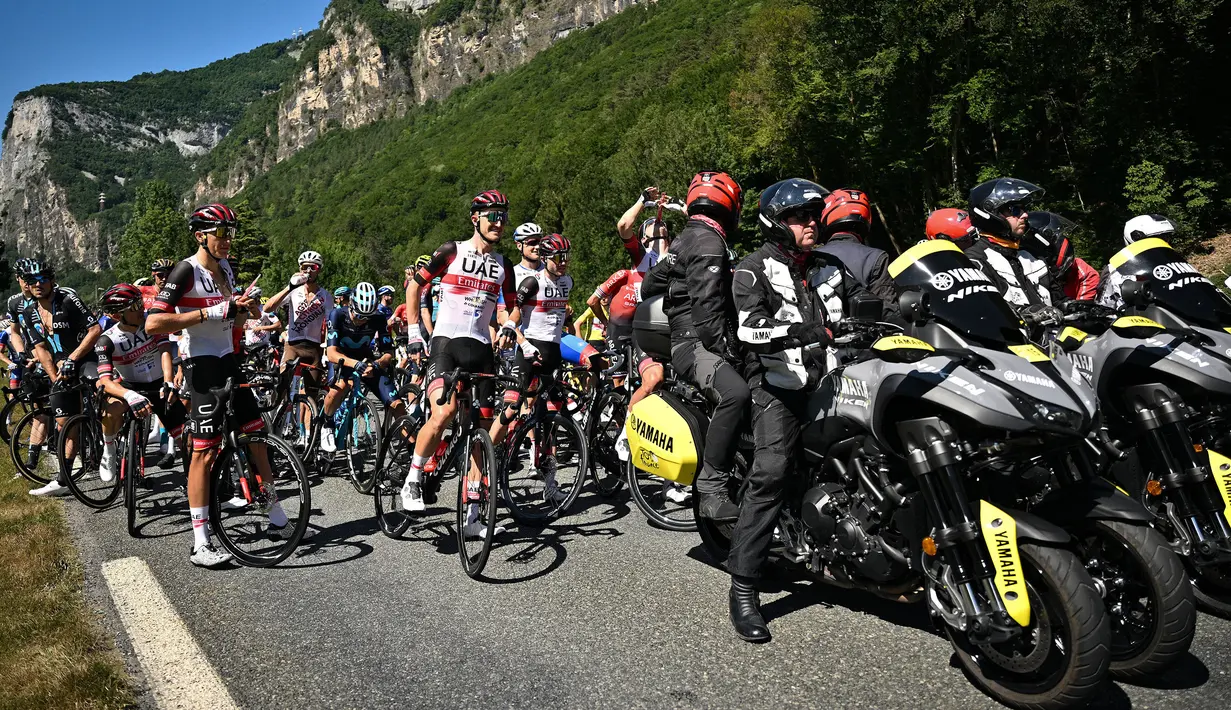 Rombongan pebalap dihentikan semenatara oleh regulator balapan karena terjadi demonstrasi perubahan iklim yang menutup rute balapan pada etape ke-10 Tour de France, antara Morzine dan Megeve, di Pegunungan Alpen Prancis, pada 12 Juli 2022. (AFP/Marco Bertorello)