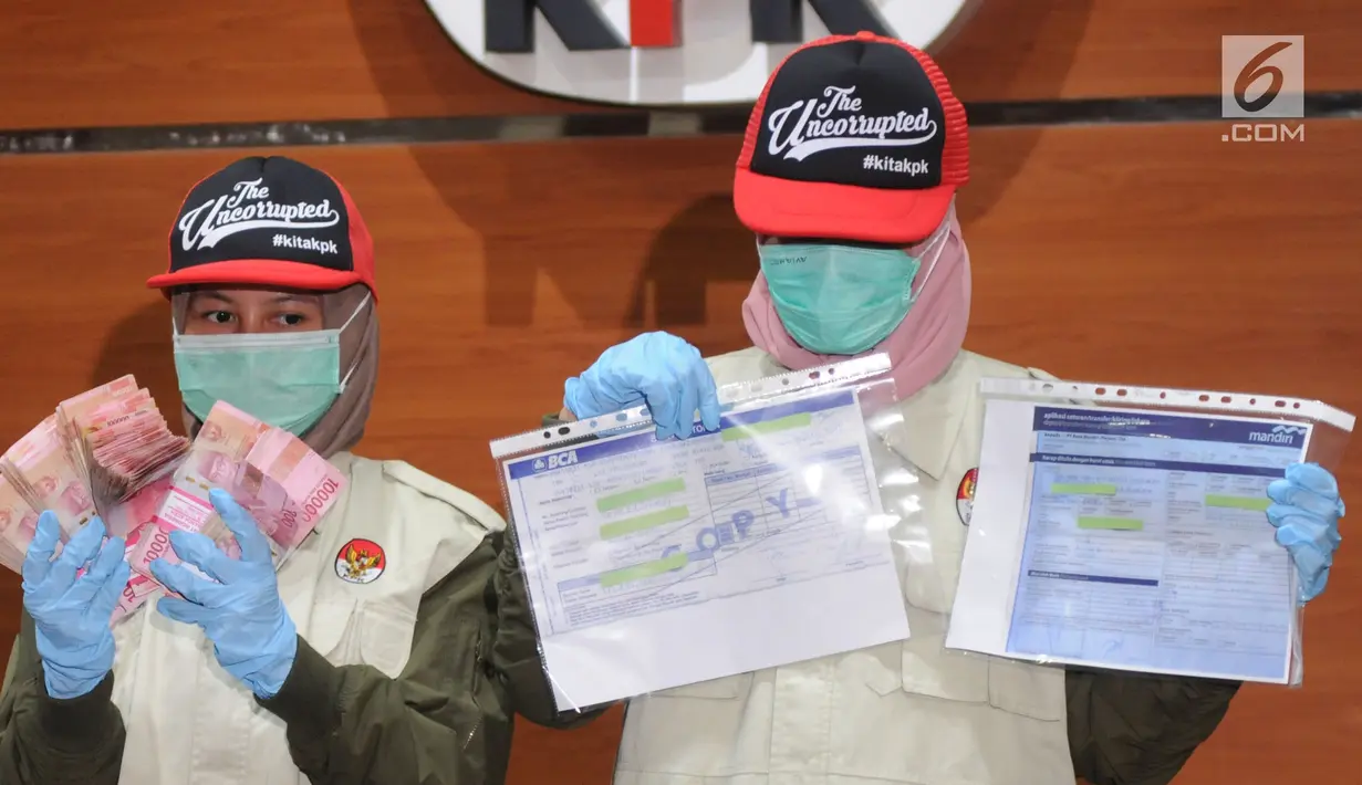 Petugas menunjukkan barang bukti hasil OTT di Aceh pada konferensi pers di Gedung KPK, Jakarta, Rabu (4/7). KPK mengamankan barang bukti uang ratusan juta dan bukti transfer diduga terkait suap dana otonomi khusus Aceh pada 2018. (Merdeka.com/Dwi Narwoko)