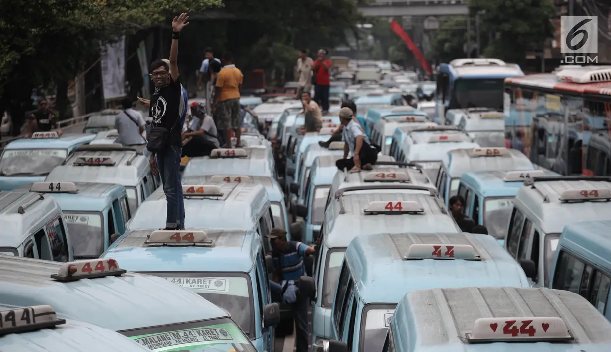 Sopir angkot trayek 44 (Jatinegara-Kampung Melayu-Tebet) memarkirkan kendaraannya saat unjuk rasa di sekitar Stasiun Tebet, Jakarta, Senin (12/2). Sopir angkot menutup akses jalan jembatan layang Tebet menuju Kampung Melayu. (Liputan6.com/Arya Manggala)