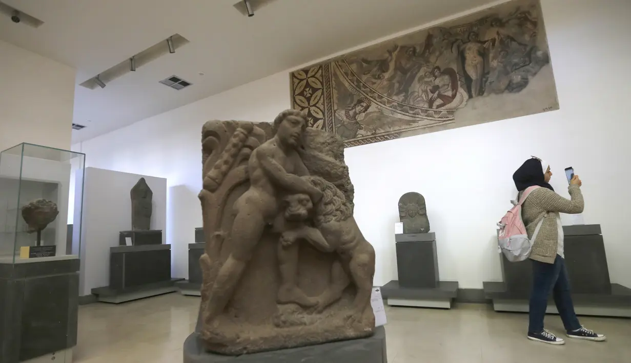 Seorang wanita mengunjungi Museum Nasional Suriah selama upacara pembukaan kembali di Damaskus, 28 Oktober 2018. Museum Nasional Suriah ini terpaksa tutup selama lebih dari enam tahun sejak konflik di Suriah pecah 2011. (Photo by LOUAI BESHARA / AFP)