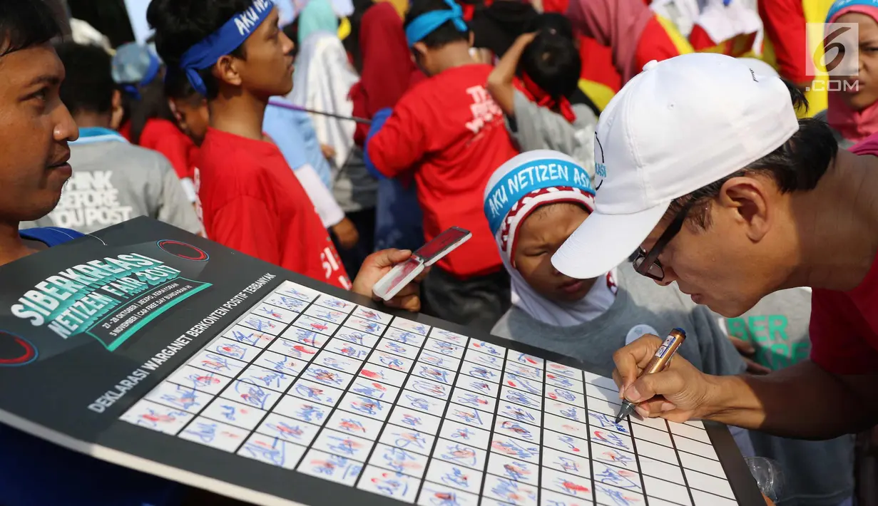 Seorang warga menandatangani dukungan deklarasi siber kreasi melawan hoax saat CFD di Jakarta, Minggu (5/11). Siber kreasi dibentuk dari berbagai komunitas dan elemen masyarakat. (Liputan6.com/Angga Yuniar)