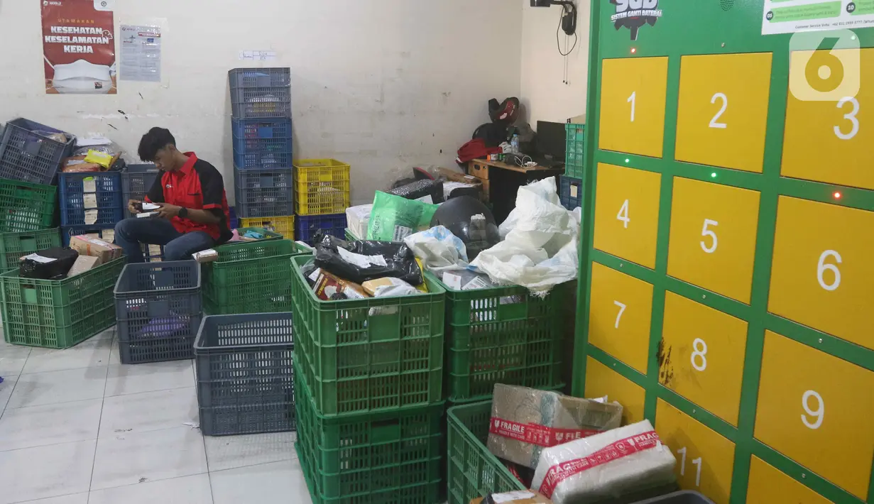 Kurir menyortir paket untuk dikirim ke alamat tujuan di salah satu gerai ekspedisi jasa di kawasan Jakarta, Senin (5/9/2022). Selain untuk mengikuti anjuran pemerintah, penggunaan motor listrik pada kurir di perusahaan ekspedisi jasa tersebut bertujuan untuk menekan biaya operasional di tengah kenaikan harga bahan bakar minyak (BBM). (Liputan6.com/Herman Zakharia)