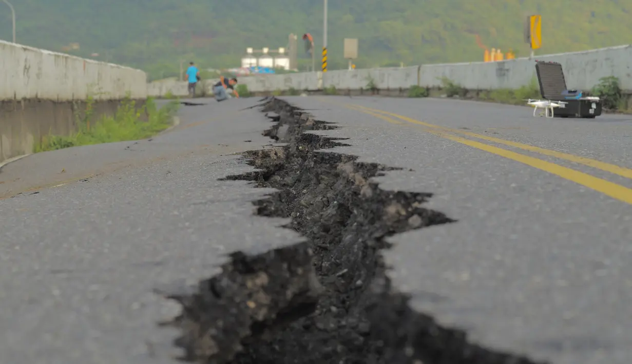 Retakan terlihat di sepanjang jalan di dekat jembatan Kaoliao yang runtuh di wilayah Hualien Taiwan timur (19/9/2022). Gempa bermagnitudo 6,9 mengguncang Kabupaten Hualien, Taiwan, pada Minggu pukul 14.44 waktu setempat (13.44 WIB). (AFP/Sam Yeh)