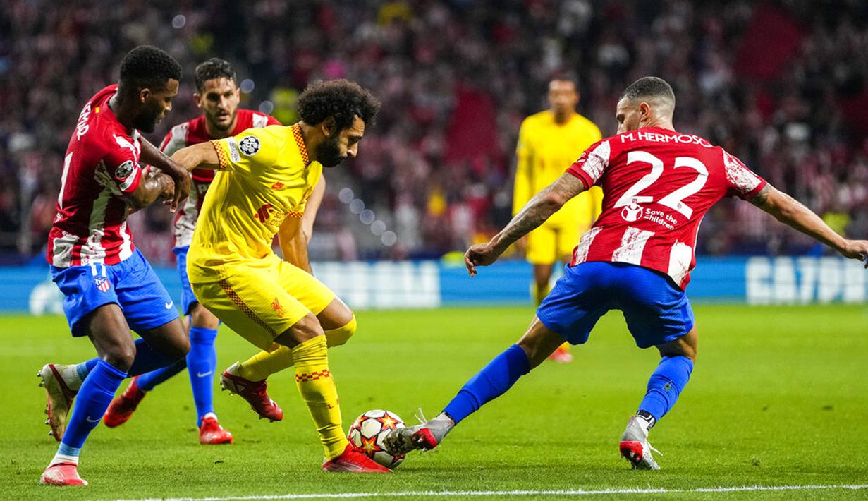 Pemain Liverpool Mohamed Salah (tengah) berduel memperebutkan bola dengan pemain Atletico Madrid Mario Hermoso (kanan) pada pertandingan sepak bola Grup B Liga Champions di Stadion Wanda Metropolitano, Madrid, Spanyol, Selasa (19/10/2021). Liverpool menang 3-2. (AP Photo/Manu Fernandez)