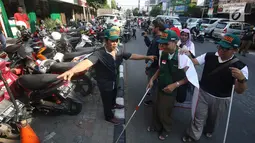 Penyandang disabilitas melintas saat kampanye Bulan Patuh Pedestrian, Jakarta, Rabu (30/8). Kampanye dilakukan untuk memantau fasilitas akses pejalan kaki untuk disabilitas yang banyak diokupasi oleh parkir liar. (Liputan6.com/Immanuel Antonius)